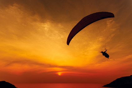 Paraglider silhouette against the background of the sunset sky